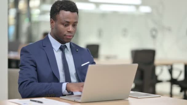 Uomo d'affari africano che lavora sul computer portatile in ufficio — Video Stock