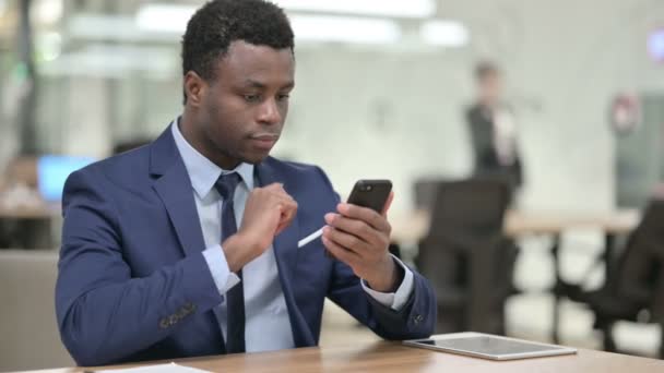 Atractivo empresario africano usando Smartphone en Office — Vídeos de Stock