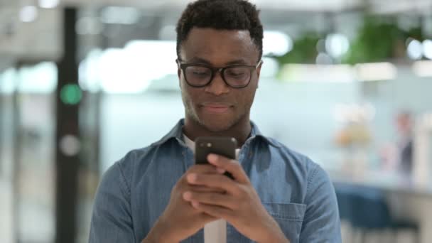 スマートフォンを使った若いアフリカ人男性の肖像 — ストック動画