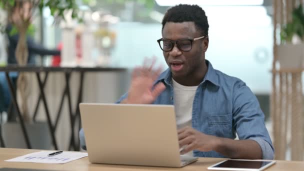 Hombre joven africano hablando en videollamada en el ordenador portátil — Vídeos de Stock