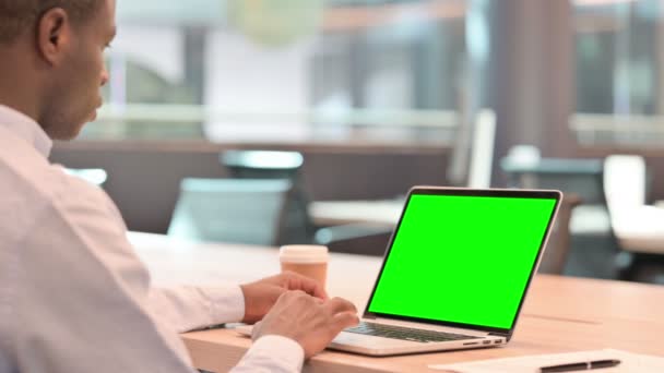 Uomo d'affari africano che utilizza il computer portatile con schermo cromato verde — Video Stock