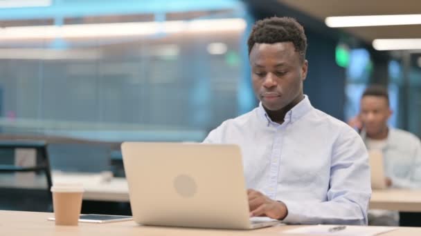 Empresário Africano se sentindo chocado ao usar o laptop no escritório — Vídeo de Stock