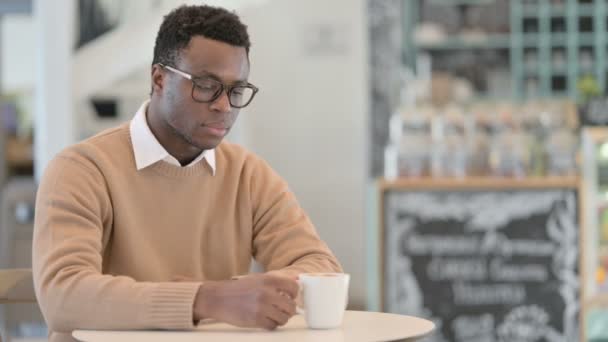 Hombre africano pensando mientras bebe café en el café — Vídeos de Stock