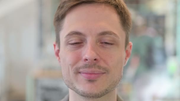 Großaufnahme des Gesichts eines jungen Mannes, der in die Kamera lächelt — Stockvideo