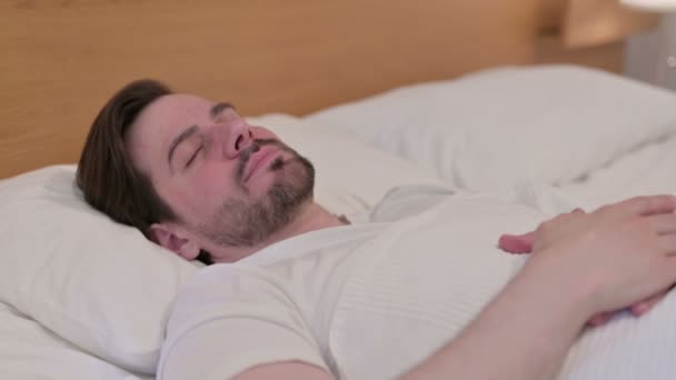 Casual giovane uomo dormire a letto pacificamente — Video Stock