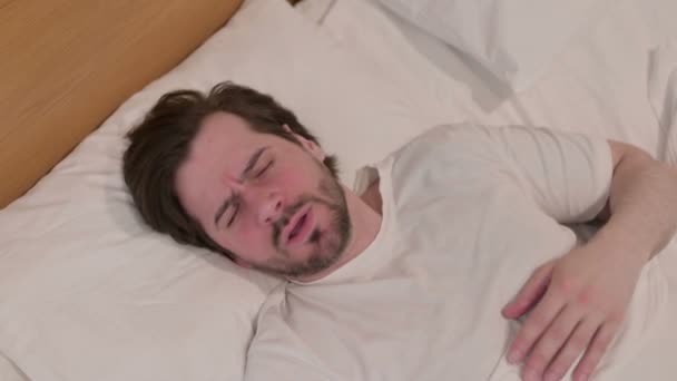 Casual jonge man hoesten terwijl slapen in bed — Stockvideo