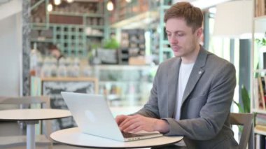 Cafe 'de laptopta çalışan genç adam. 