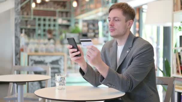 Giovane uomo che effettua il pagamento online su Smartphone in Cafe — Video Stock