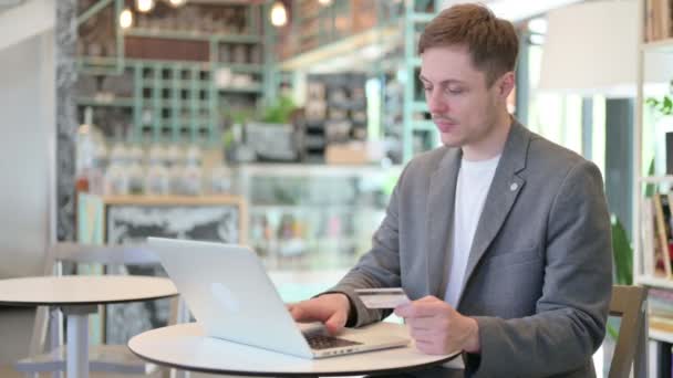 Успешная онлайн оплата на ноутбуке от молодого человека — стоковое видео