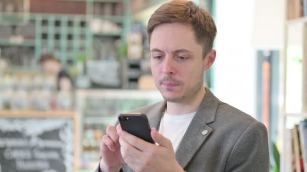Portrét ztráty mladého muže na smartphonu — Stock video