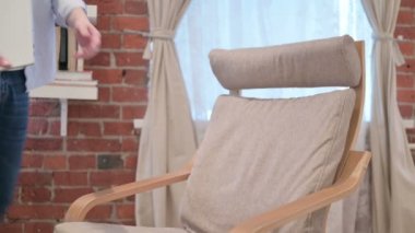 Gelişigüzel genç adam kanepeye oturdu, dizüstü bilgisayar açılıyor.