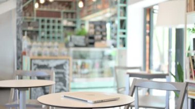 Genç adam geri dönüyor ve Cafe 'de laptop açıyor.