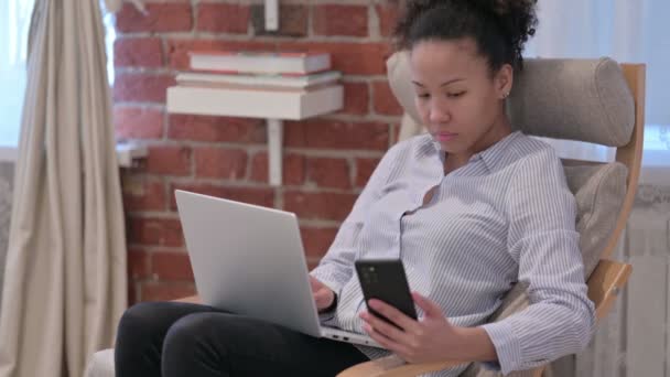 African American Woman με Laptop χρησιμοποιώντας Smartphone — Αρχείο Βίντεο