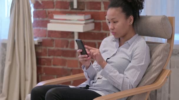 Ελκυστική African American Woman χρησιμοποιώντας Smartphone στο σπίτι — Αρχείο Βίντεο