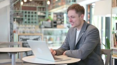 Videodaki Genç Adam Laptop 'tan arıyor. 