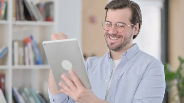 Portrait de l'homme en lunettes célébrant le succès sur tablette — Photo