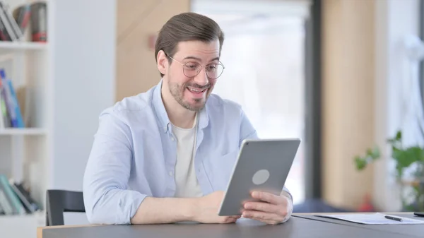 Uomo in occhiali fare videochiamata su tablet in ufficio — Foto Stock