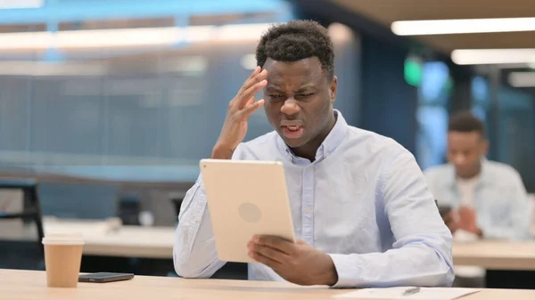 Africký podnikatel reagující na ztrátu na tabletu — Stock fotografie