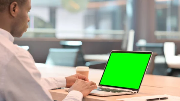Empresario africano usando el ordenador portátil con la pantalla verde del croma —  Fotos de Stock