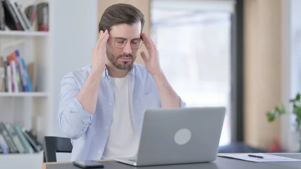 Homem cansado em óculos com laptop com dor de cabeça — Fotografia de Stock