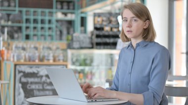 Bilgisayarda çalışırken Kameraya Bakan Genç Kadın 