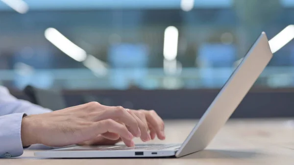 Hände in Großaufnahme von jungem Mann, der auf Laptop tippt — Stockfoto