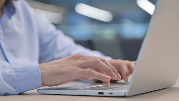 Hände in Großaufnahme von jungem Mann, der auf Laptop tippt — Stockfoto