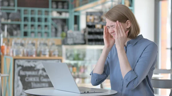 Giovane donna con mal di testa che lavora sul computer portatile — Foto Stock