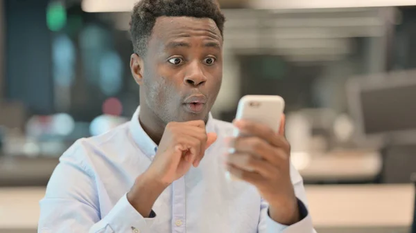 Portrét afrického podnikatele slavícího na Smartphonu — Stock fotografie