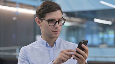 Akıllı telefon kullanan genç adamın portresi