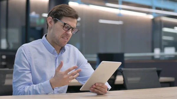 Ung mann med tap av nettbrett på jobben – stockfoto