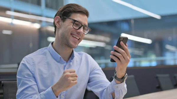 Young Man Celebrating Success on Smartphone — Stock Photo, Image