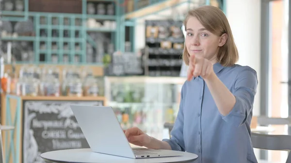 Mulher jovem com laptop apontando para câmera — Fotografia de Stock