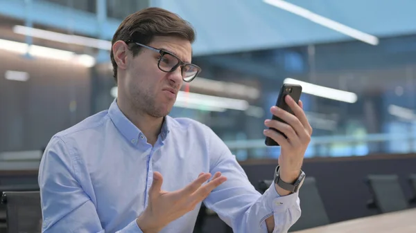 Hombre joven reaccionando a la pérdida en el Smartphone —  Fotos de Stock