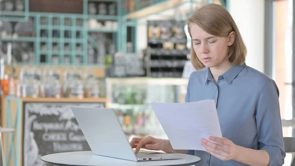 Fiatal nő olvasás dokumentumok használata közben Laptop — Stock Fotó