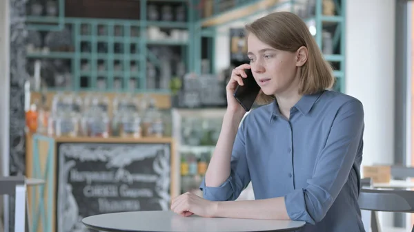 Junge Frau spricht im Café mit Smartphone — Stockfoto