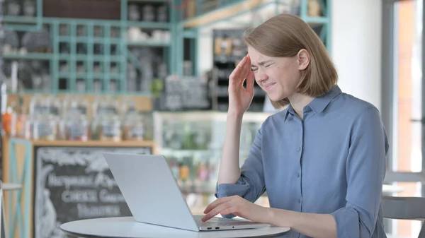 Junge Frau mit Kopfschmerzen benutzt Laptop — Stockfoto
