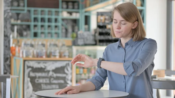 Mladá žena kontrola hodinky při čekání — Stock fotografie