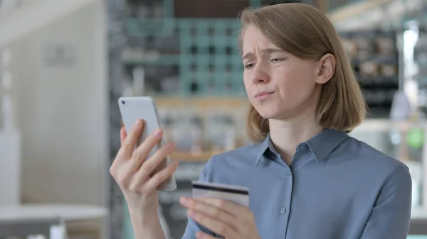 スマートフォンでオンラインショッピングに失敗した若い女性 — ストック写真