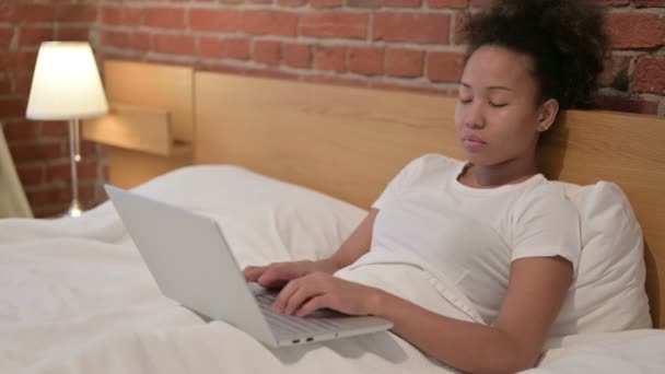 Mujer africana con portátil tomando siesta en la cama — Vídeos de Stock