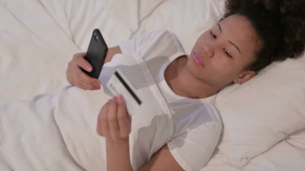 ベッドでスマートフォンでオンライン決済の失敗を持つアフリカの女性 — ストック動画