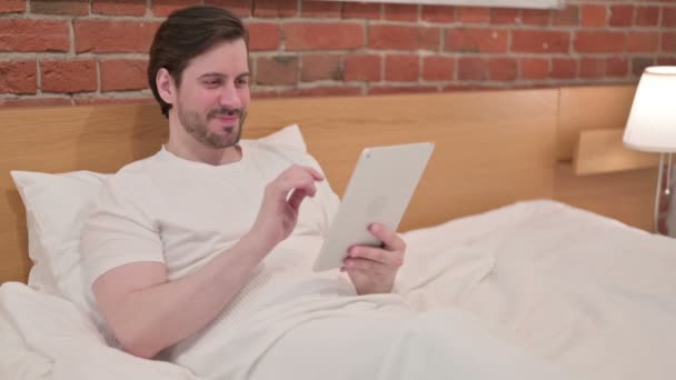 Casual Young Man κάνει Video Call on Tablet στο κρεβάτι — Αρχείο Βίντεο