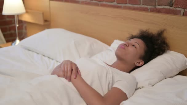 Joven mujer africana despierta en la cama pensando — Vídeo de stock