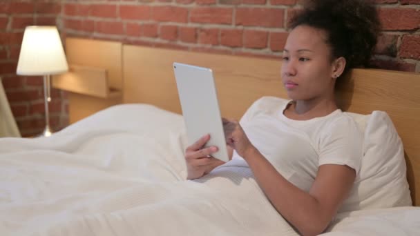 Mujer africana reaccionando a la pérdida en la tableta en la cama — Vídeos de Stock
