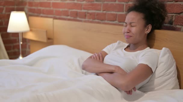 Afrikansk kvinna känner sig orolig när hon sitter i sängen — Stockvideo