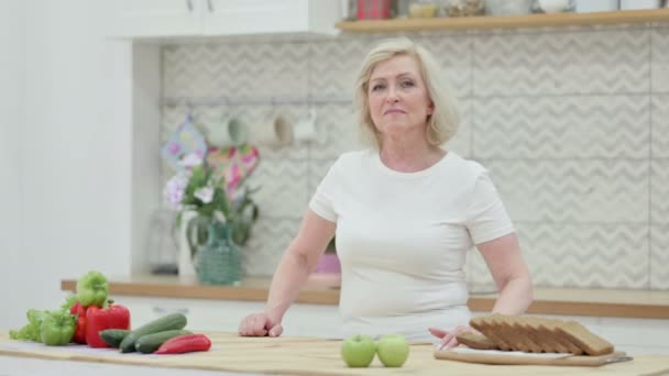 Starší stará žena třese hlavou jako ne znamení, zatímco v kuchyni — Stock video