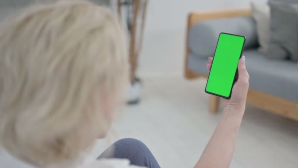 Vue arrière de la vieille femme âgée regardant Smartphone avec écran Chroma Key sur tapis de yoga — Video