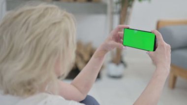 Kıdemli Yaşlı Kadın, Yoga Mat 'te Chroma Key Ekranı ile Akıllı Telefon Kullanırken Arka Görünümü