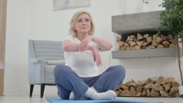 Hälsosam äldre kvinna mediterar på Yogamattan hemma — Stockvideo