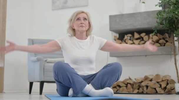 Senior gammal kvinna gör yoga på yogamattan hemma — Stockvideo